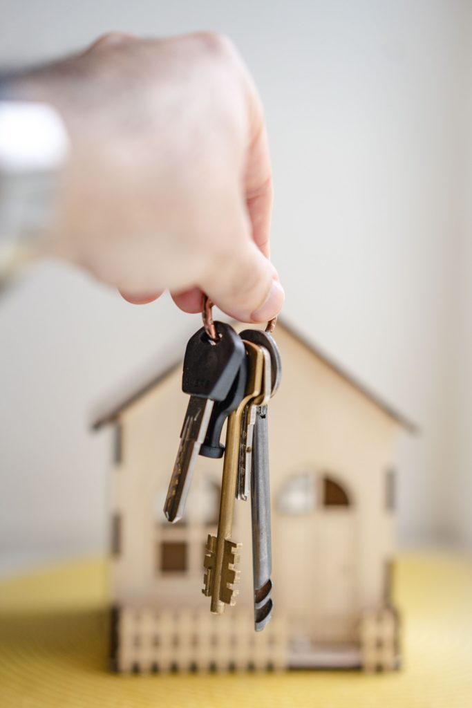 a set of keys in front of a small model house